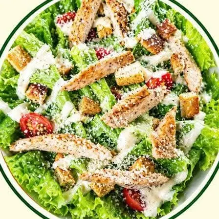 Caesar salad with sliced grilled chicken, croutons and cherry tomatoes.